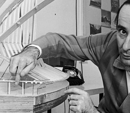 A man pointing towards the glass model of Sydney opera house.