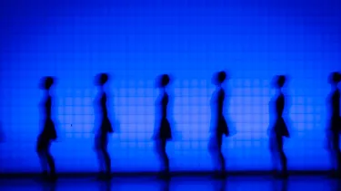 Six ballet dancers stands against a blue screen.
