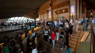 Audience members walk down the stairs of the Sydney Opera House Concert Hall.
