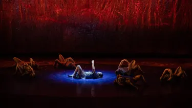 A group of dancers performing a traditional Aboriginal dance on a stage.