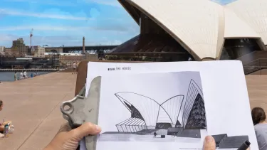 A hand drawn picture of the Sydney Opera House on a clipboard