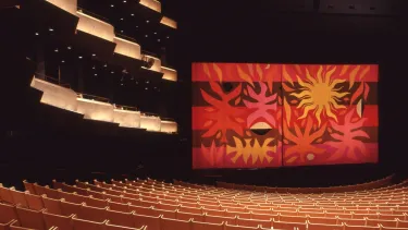A curtain in the Concert hall with tapestry art on it.