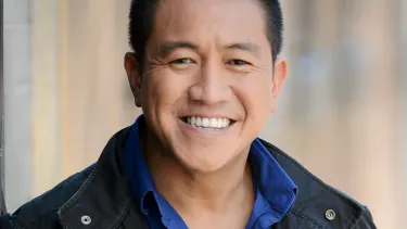 A man in blue shirt and black jacket.