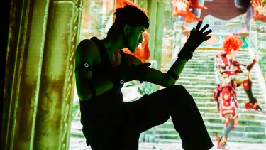 A man wearing a virtual gear to shadow a digital character on the screen.