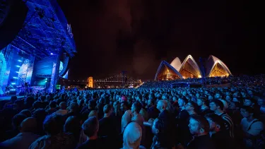 Concertgoers at a show outside in front of the Sydney Opera House.