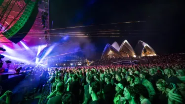 Concertgoers at a show outside in front of the Sydney Opera House.