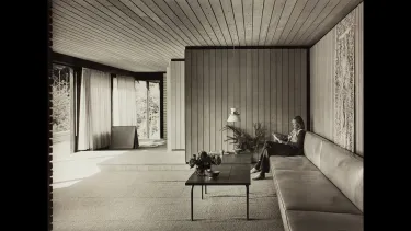 A woman sitting and reading on a sofa.