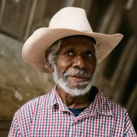 A portrait of Mervyn Street wearing a wide brim hat inside the Sydney Opera House.