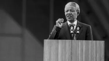 Former president of South Africa Nelson Mandela giving speech standing on a podium.