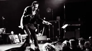 A man in a suit singing on the stage.