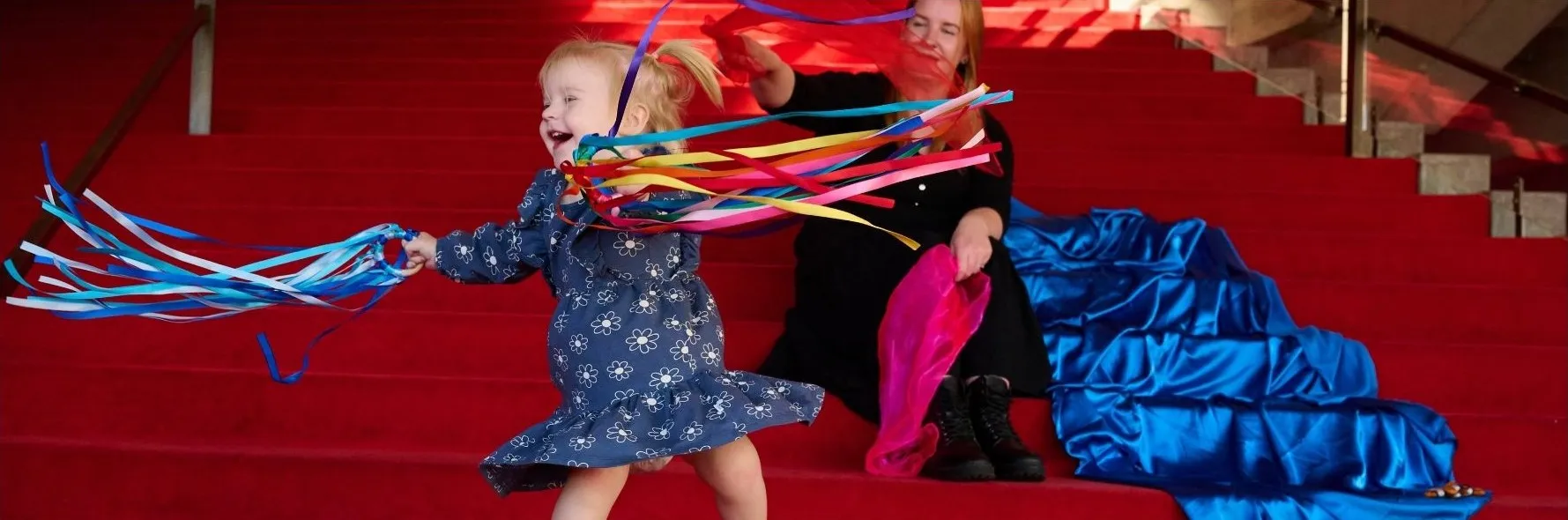 A little girl holding cheering pompom.