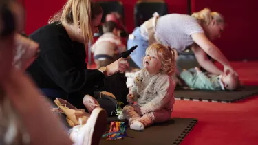 Mums take care of their toddlers lying down on the Joan Sutherland Theatre floor.