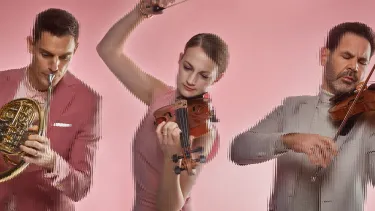 Three artists playing a violins and a tuba, against a pink background.