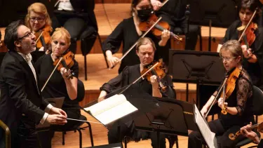 Umberto Clerici conducts an orchestra.