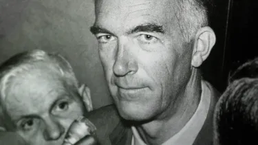 A close up of Jorn Utzon with a small smile on his face.